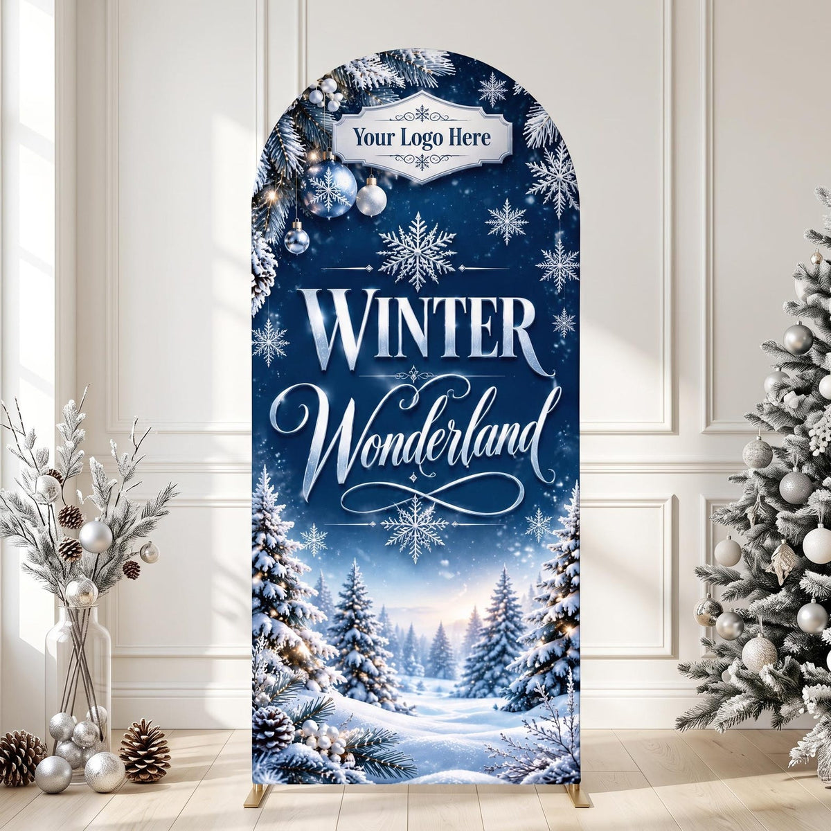 May include: An arched backdrop display featuring a deep blue winter landscape with snow-covered pine trees, snowflakes, and ornaments. The text reads "Winter Wonderland" in white script and block letters, with a "Your Logo Here" label.